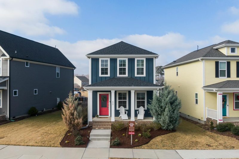 Aerial view of stylish suburban homes featuring modern architecture in a tree-lined neighborhood.
