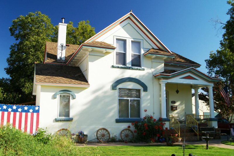 Suburban house with a well-kept front yard and vibrant patriotic decorations.