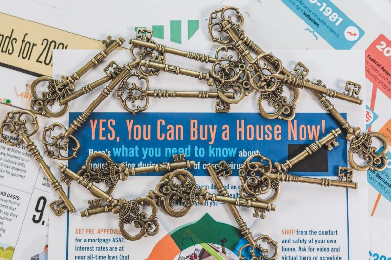 Vintage keys scattered atop real estate documents, representing property ownership and investment.